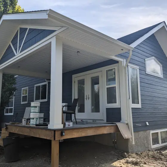 New navy lap siding, white trim and covered deck on a renovated bungalow