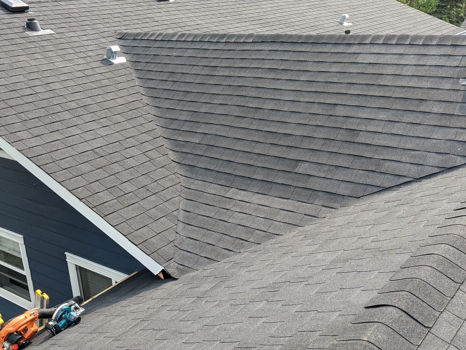 New architectural asphalt shingles across valleys and hips, mid-install