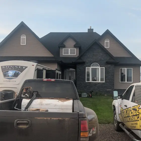 Acreage home with a new asphalt roof — our truck and trailer on site