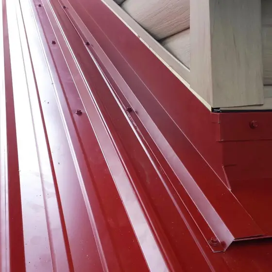 Red metal roofing with hand-formed curb and flashing detail