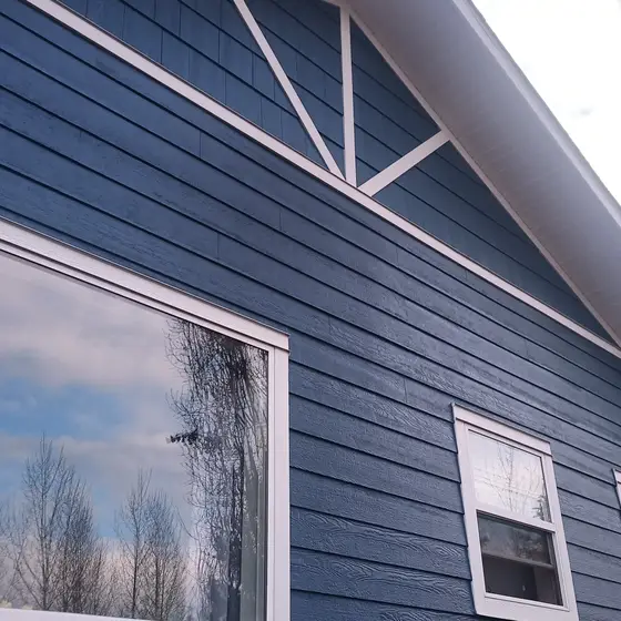 Navy lap siding with white gable truss accents, up close