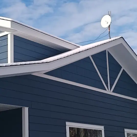 Snow-edged gable with fresh siding and white fascia