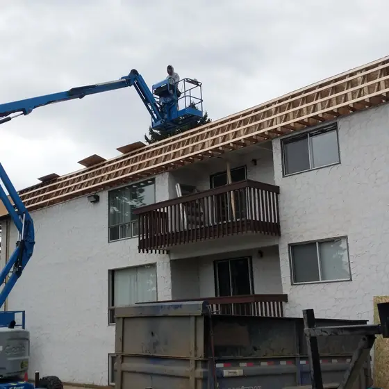 Fascia and roof-edge rebuild on an apartment building, from a boom lift