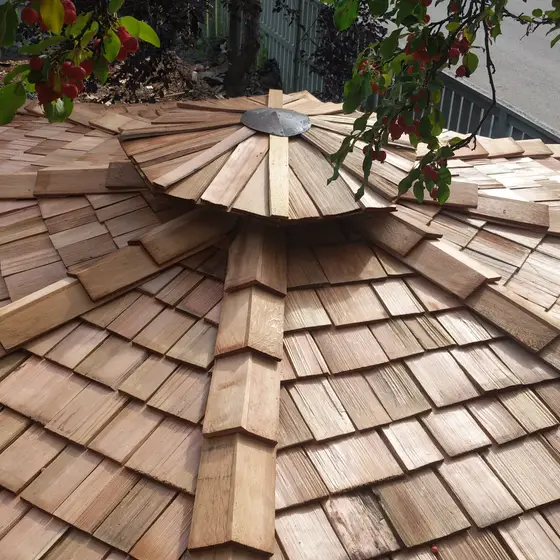Hand-built cedar shake turret roof with a steel cap