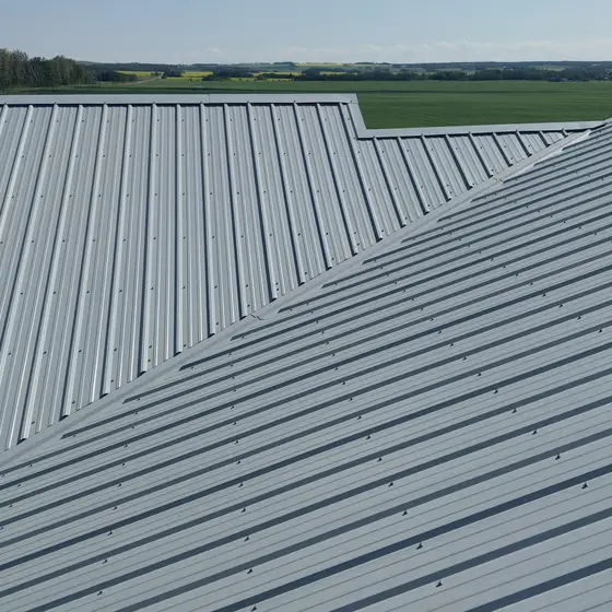 Wide agricultural building re-roofed in metal