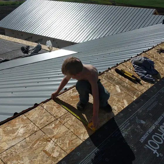 Panel measurement on the roof deck, metal re-roof in progress